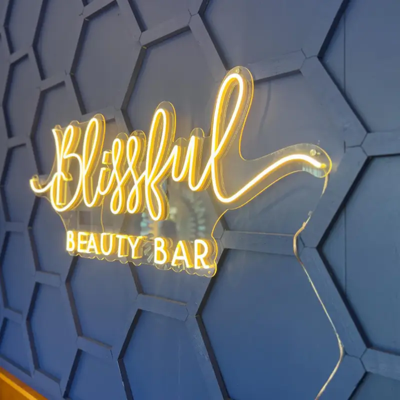 Blissful Beauty Bar neon sign on blue honeycomb wall in Niceville, FL | Blissful Beauty Bar